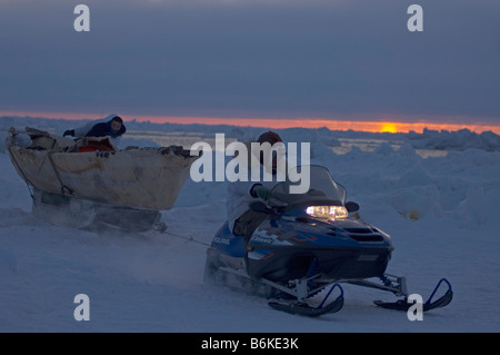 Inupiaq subsistence whalers haul their seal skin boat or umiak away from an open lead in the pack ice Chukchi Sea outside Stock Photo