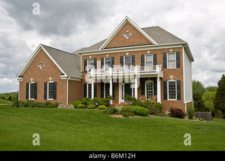 Front view of large modern single family house in the suburbs on a cloudy day Stock Photo