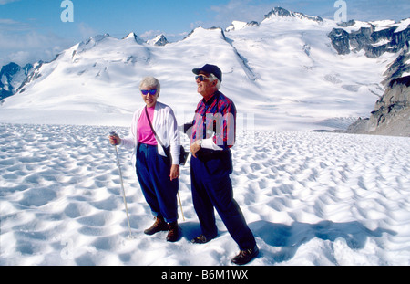 Couple hiking with ski poles on Malloy Glacier in the Bugaboos, Purcell Range, British Columbia, Canada Stock Photo