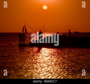 fishermans on the beach in the sunset Stock Photo