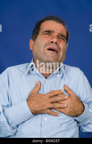 Man hands grabbing chest having a heart attack Stock Photo