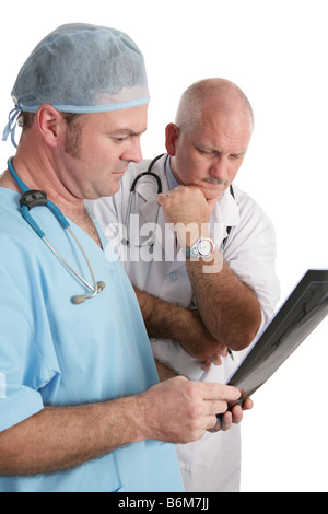 Two concerned doctors reviewing xrays Focus on mature doctor in white lab coat Stock Photo