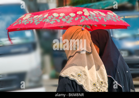 Two Indian women walking across street in Little India Singapore Stock Photo