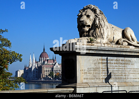 Close-up of a stone lion sculpture at Széchenyi Chain Bridge in Budapest, Hungary, with the parliament building in background Stock Photo