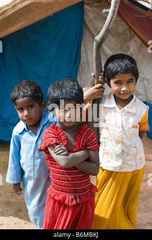 Happy Poor indian children standing outside their tent home. Andhra Pradesh, India Stock Photo