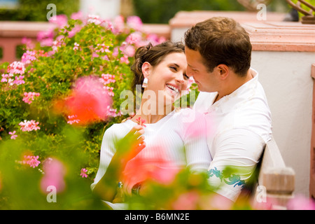 A young Caucasian couple cuddling in garden Stock Photo