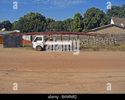 Roof trusses being loaded on a small van in The Gambia, West Africa Stock Photo