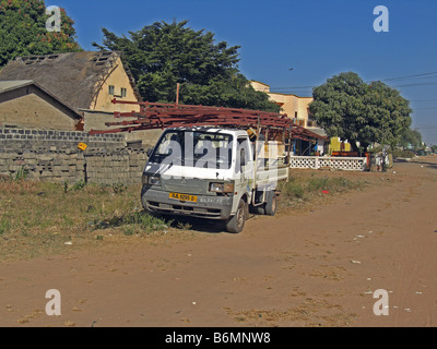 Roof trusses being loaded on a small van in The Gambia, West Africa Stock Photo