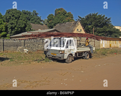 Roof trusses being loaded on a small van in The Gambia, West Africa Stock Photo