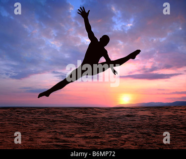 A silhouette of a jumping man on a colorful sunset background Stock Photo