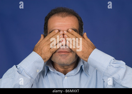 Man covering eyes with hands Stock Photo