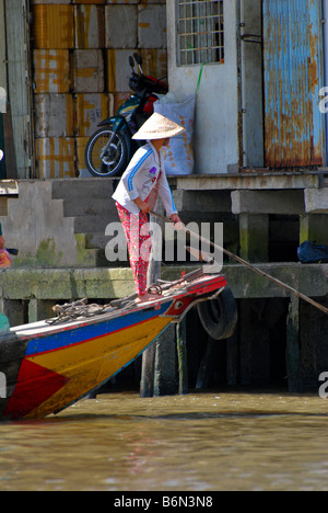 Vietnamese boatwoman skulling from sampan, town of Cai Be, Mekong Delta, Vietnam Stock Photo