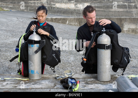 Man and Woman Preparing To Go Scuba Diving, Taiwan, Green Island Stock Photo