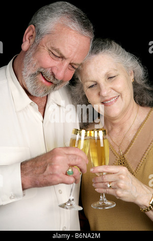 A successful middle aged couple celebrating with glasses of champagne Isolated on black Stock Photo
