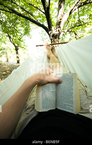 Reading a book in a hammock Stock Photo