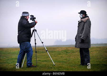 A VISITOR TO STONEHENGE WEARING A WHITEFACE CLOWN MASK IS PHOTOGRAPHED DURING THE CELEBRATIONS OF THE WINTER SOLSTICE WILTSHIRE Stock Photo