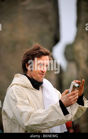 A DRUID TAKES A PICTURE AT STONEHENGE DURING CELEBRATIONS OF THE WINTER SOLSTICE WILTSHIRE UK Stock Photo