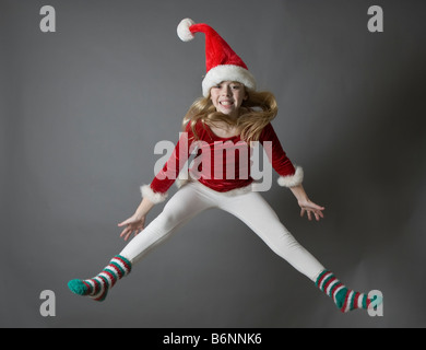 Child jumping wearing a Santa hat Stock Photo