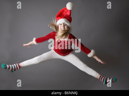 Child jumping wearing a Santa hat Stock Photo
