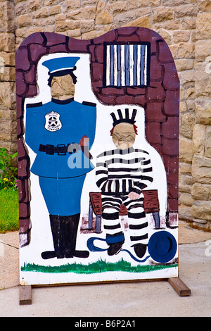 Image of a cardboard photo op showing an old fashioned prison guard and a prisoner sitting outside the Deer Lodge Prison Stock Photo