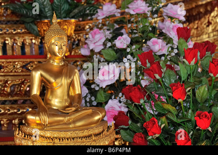 Buddha statue with red and pink roses in buddhist temple in Bangkok's chinatown, Thailand Stock Photo