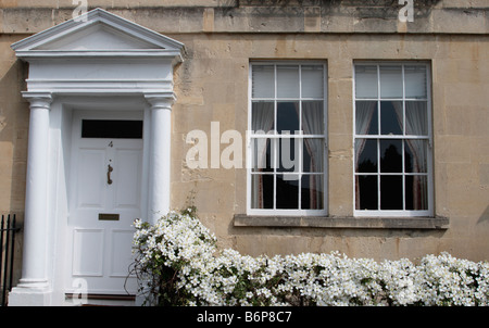 Bath Somerset UK Architectural detail of Georgian town house front door with pedimented porch, sash windows and clematis Stock Photo