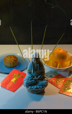Chinese New Year, Buddha, inscents, moon cakes, oranges, red money packets, Hong Bao, Ang Pao and Lai See. Stock Photo