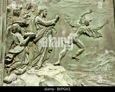Pisa, Italy. Detail of the bronze doors of the Duomo, showing Satan being cast out of heaven by St Michael (by Giambologna, 1602) Stock Photo