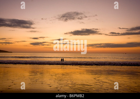 Couple enjoys the beach at sunset on Flamingo Beach in Costa Rica Stock Photo