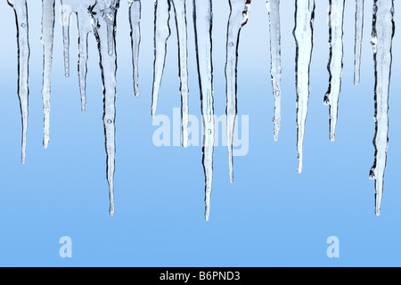 Icicles on blue background Stock Photo
