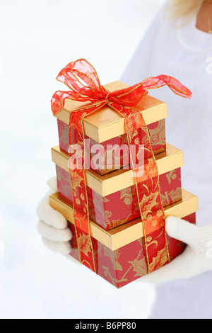 Hands with winter gloves holding Christmas present Stock Photo
