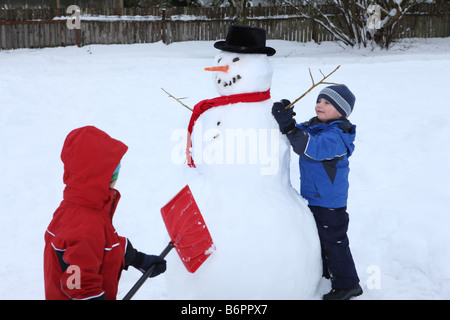 Two young boys building snowman Stock Photo