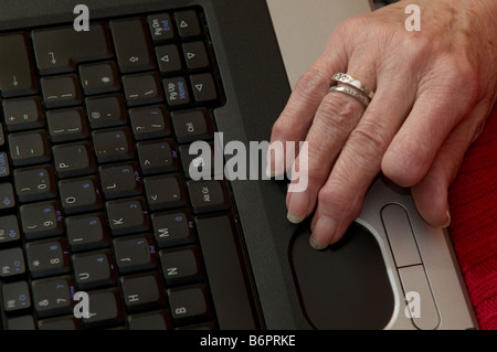 close up of the hand of an octogenarian woman 80 year old using her laptop computer to chat online with her family,  Wales UK Stock Photo