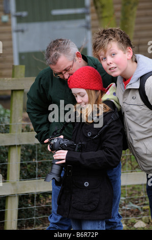 Small girl and a boy learning to use a SLR digital camera Stock Photo