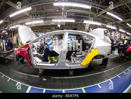 Workers at Toyota Final Assembly production line fit parts to the inside of a Toyota Avensis car Stock Photo