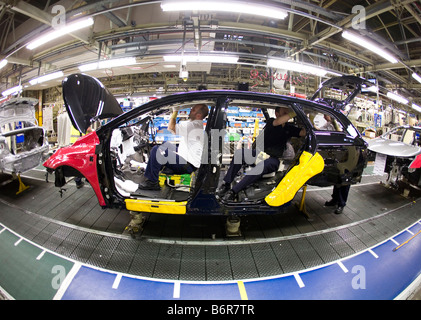 Workers at Toyota Final Assembly production line fit parts to the inside of a Toyota Avensis car Stock Photo