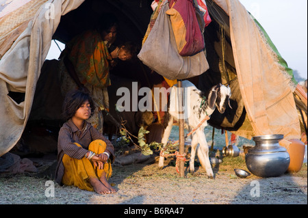 Poor nomadic Indian girl sitting in her tent in the early morning light. Andhra Pradesh, India Stock Photo