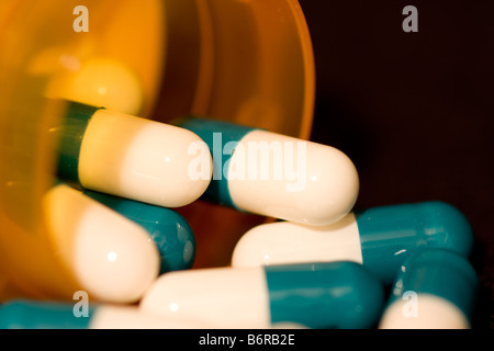 Pharmaceutical capsules spilling out of a prescription bottle Stock Photo