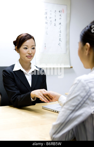 Two Business women shaking hands in the office Stock Photo