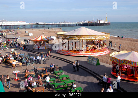 View of carousel on the sea front with Brighton Pier formerly Palace Pier on a summers day in Brighton UK Stock Photo