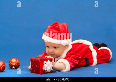 baby in santa's suit with gift and balls Stock Photo