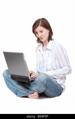 amazed woman with notebook sitting on the floor Stock Photo