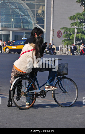 Chinese couple on a bicycle next to Xidan shopping center Beijing China Stock Photo