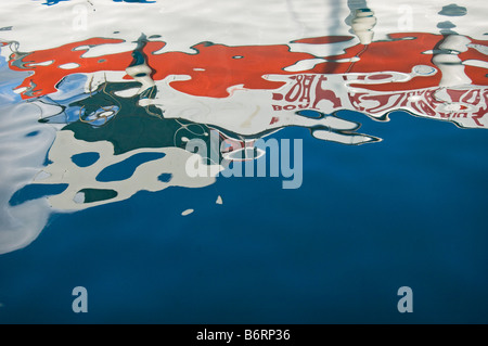 Boats reflected in the smooth water in the harbour of the Greek Island of Symi (or Simi) near Rhodes Greece Stock Photo