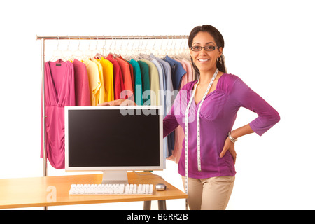Young Hispanic fashion designer standing at work table with computer Stock Photo