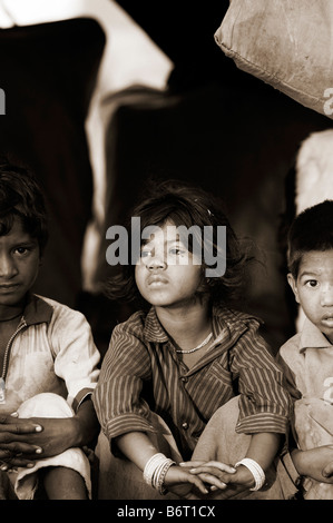 Poor nomadic indian girl sitting inside her tent home. Andhra Pradesh, India.  Sepia tone Stock Photo