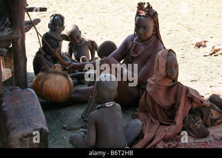 Namibia, Himba woman rocking milk in calabash Stock Photo