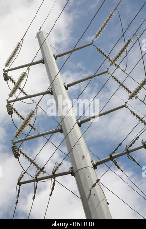 electrical utility pole with many wires in patterns against sky Stock Photo