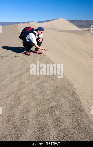 A hiker feels the sand on a sand dune above the White Bluffs of the Hanford Reach along the Columbia River Washington Stock Photo