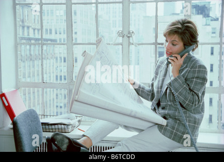 Young woman with blueprints talking on a landline phone, USA  1999 Stock Photo